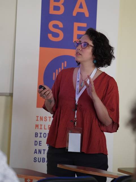 Una mujer presenta información durante una charla en un ambiente académico.