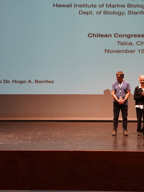 Una presentación en el Congreso Chileno de Zoología con cuatro personas en un escenario.