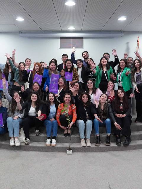 Grupo de personas sonriendo y levantando las manos en un evento de celebración.