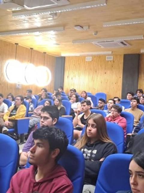 Un grupo de estudiantes sentados en un aula durante una presentación.