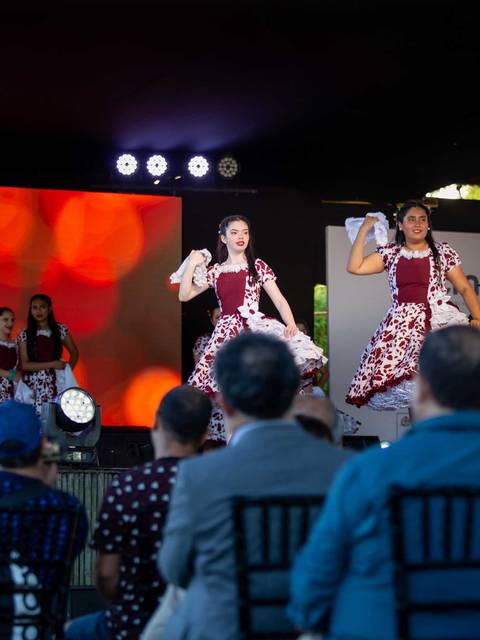 Un grupo de bailarinas presenta un espectáculo folclórico en la Feria de Huilquilemu frente a un público atento.