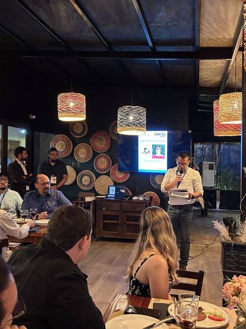 Un grupo de personas se reúne en un restaurante para escuchar una presentación.