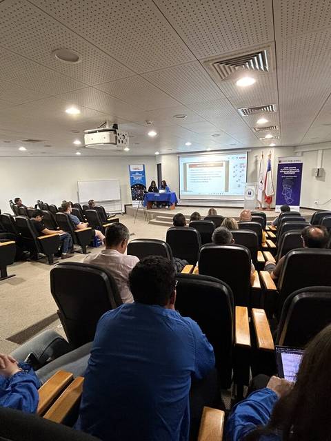 Un grupo de personas asiste a una presentación en un auditorio.