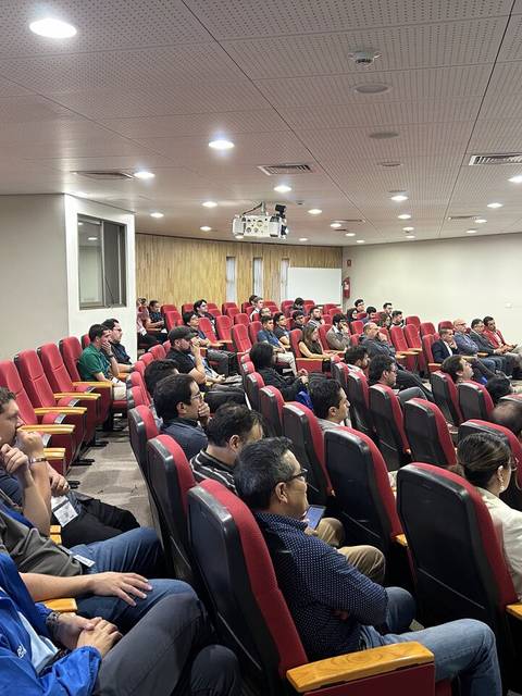Sala de conferencias con una audiencia atenta en un evento.