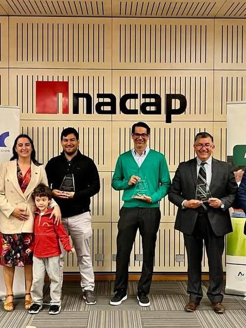 Un grupo de personas sonrientes sosteniendo trofeos en un evento en las instalaciones de NACAP.