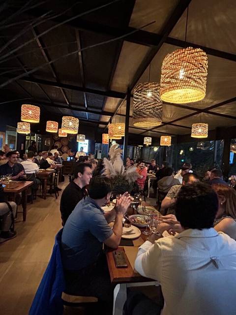 Un restaurante lleno de gente disfrutando de una cena en un ambiente acogedor.
