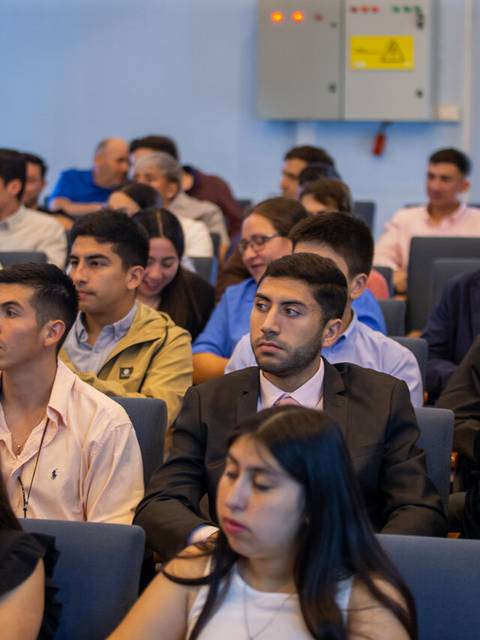 Un grupo de jóvenes sentados en un auditorio durante un evento.