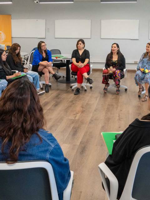 Un grupo de mujeres está participando en una reunión en un aula moderna.