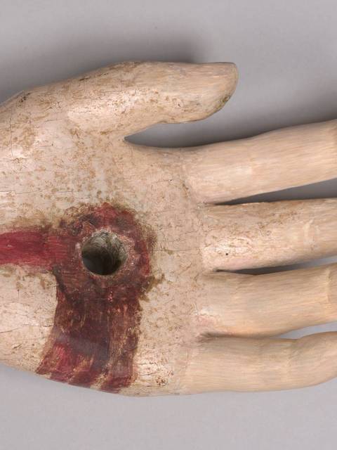 Un modelo de mano pintado con un agujero en la palma.