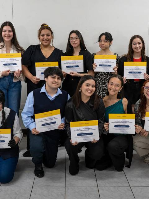 Un grupo de personas sosteniendo sus certificados en un evento de entrega de premios.