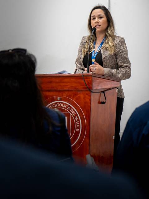 Una mujer está hablando desde un podio en un evento formal.