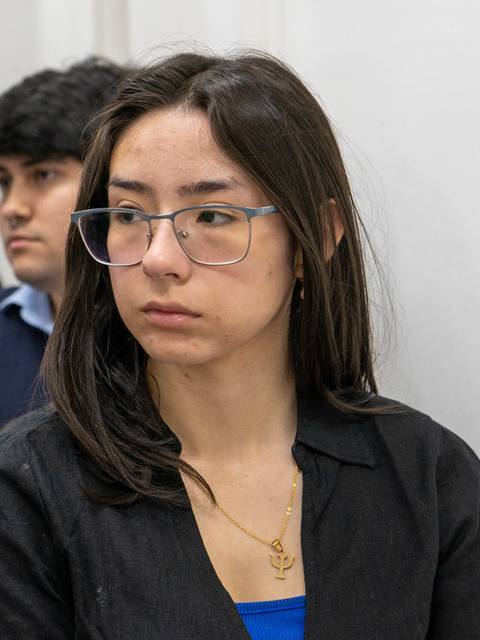 Un grupo de personas sentadas en una sala, prestando atención a un evento o charla.