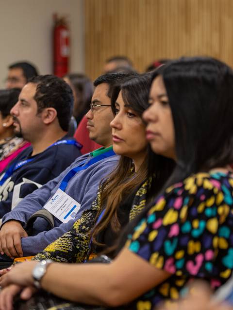 Un grupo de personas atentas en una conferencia o presentación.