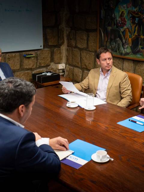 Reunión de un grupo de profesionales alrededor de una mesa en un entorno formal.
