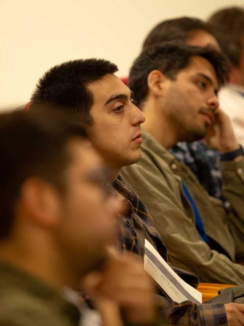 Un grupo de personas escuchando atentamente en una sala de conferencias.