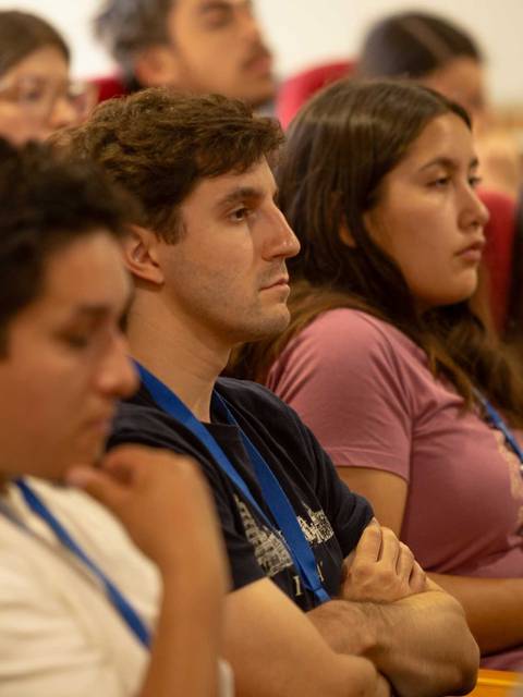 Un grupo de personas escucha atentamente en un evento o conferencia.