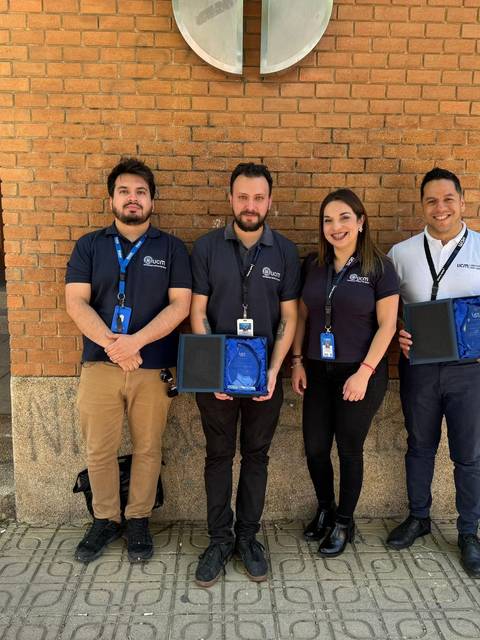 Un grupo de cuatro personas posando frente a un edificio.
