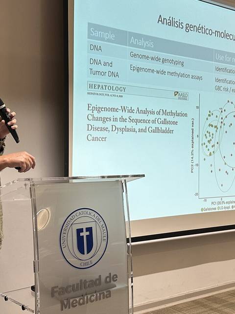 Un presentador expone sobre análisis genético-molecular en un aula universitaria.
