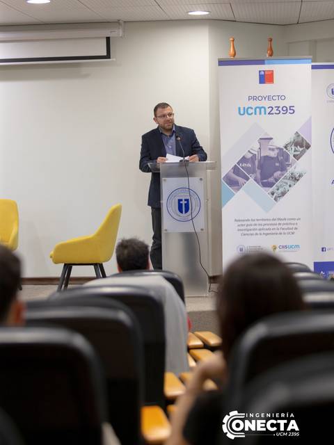 Un orador presenta un proyecto frente a una audiencia en un evento académico.