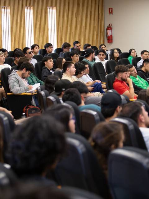 Un grupo de personas sentadas en un auditorio durante una conferencia.