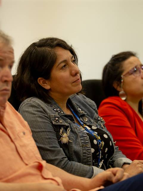 Un grupo de personas escucha atentamente durante una presentación.