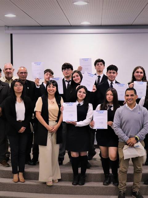 Un grupo de estudiantes y profesores posan con sus certificados en un evento de entrega.