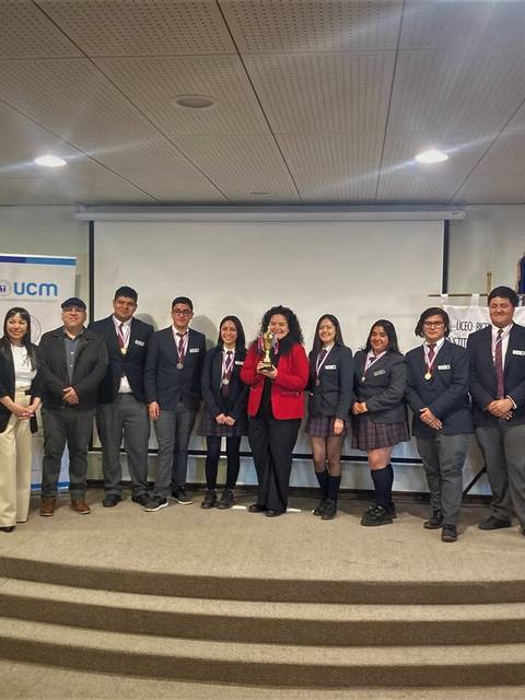 Un grupo de estudiantes y profesores posan en un auditorio tras un evento académico.