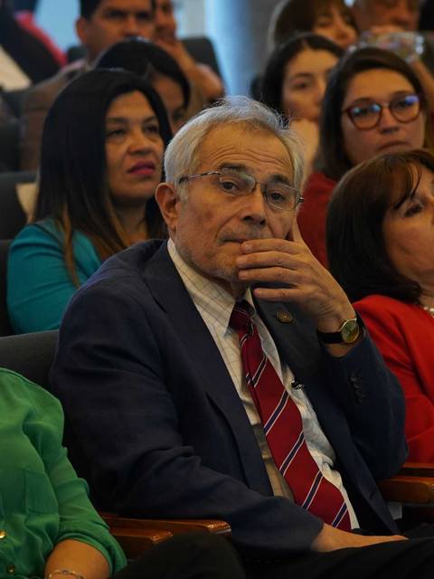 Un grupo de personas sentadas en un auditorio durante un evento.