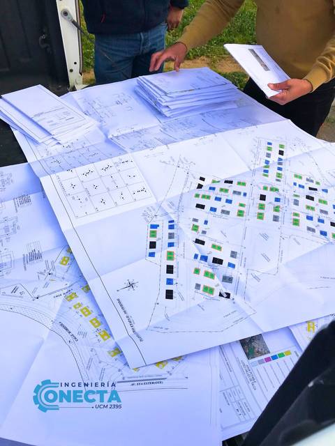 Una mesa repleta de planos y documentos relacionados con proyectos de ingeniería.