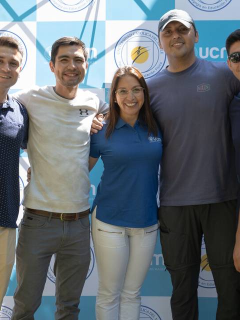 Grupo de amigos posando juntos en un evento al aire libre.