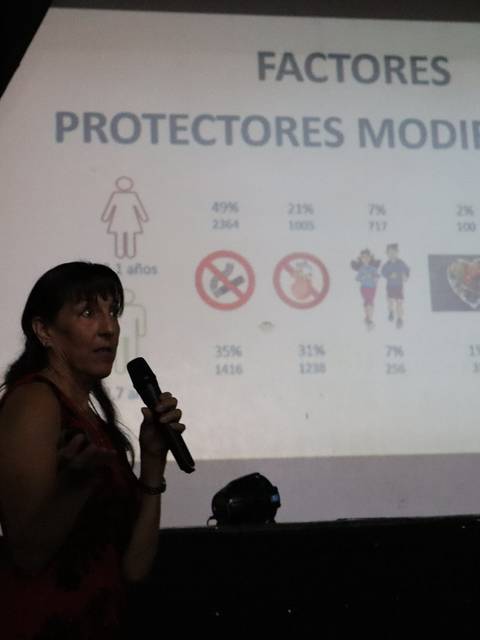 Una presentadora habla sobre factores protectores modificables en una charla.