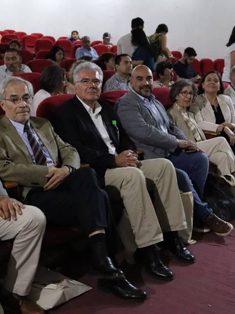 Un grupo de personas sentadas en un auditorio durante un evento.
