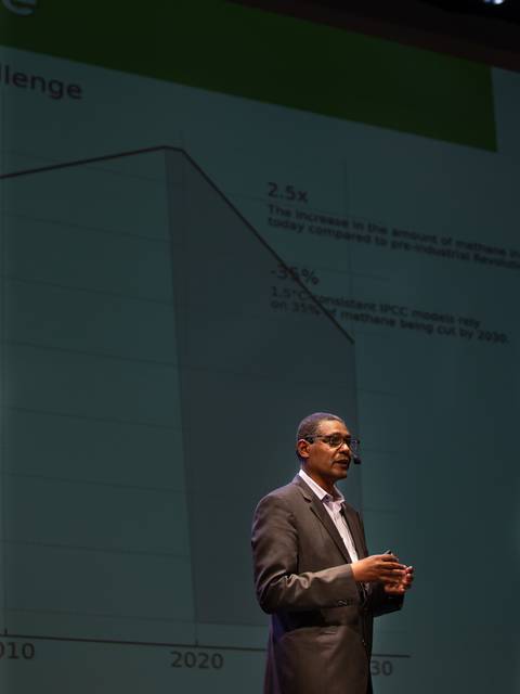 Un presentador habla sobre un gráfico que muestra el aumento de la cantidad de emisiones de carbono a lo largo del tiempo.