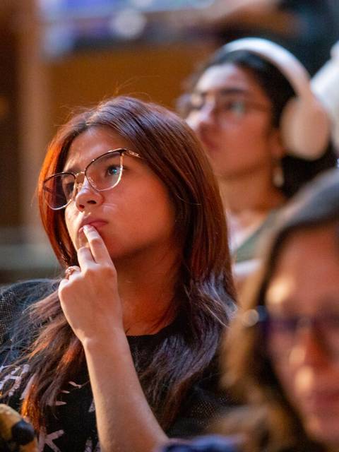 Grupo de personas escuchando atentamente en un evento o conferencia.