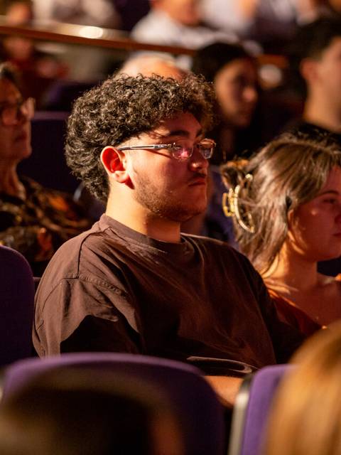 Un grupo de personas mirando atentamente en un auditorio.