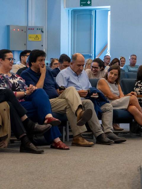 Un grupo de personas sentadas en un auditorio durante un evento.