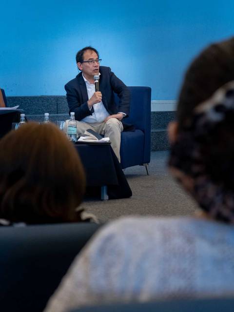 Un hombre en una conferencia habla mientras el público lo observa.