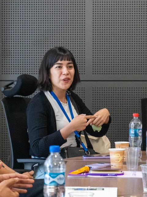 Un grupo de personas está conversando en una reunión en una sala.