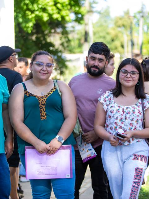 Grupo de cinco personas posando sonrientes al aire libre.