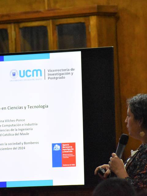 Una mujer presenta un tema sobre brechas de género en ciencias y tecnología ante un público en un auditorio.