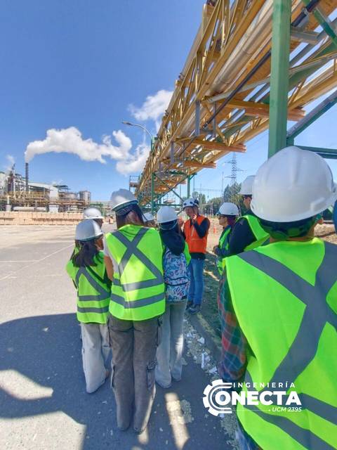 Grupo de trabajadores en un sitio industrial escuchando una charla de seguridad.