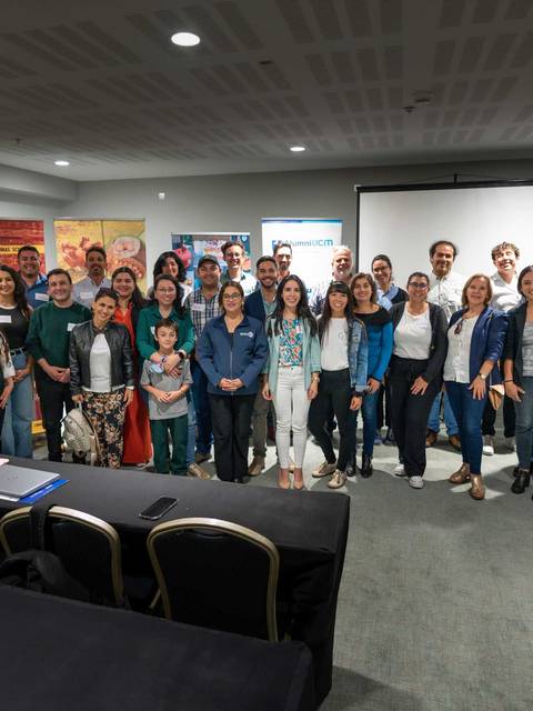 Un grupo diverso de personas posando juntas en un evento en un salón.