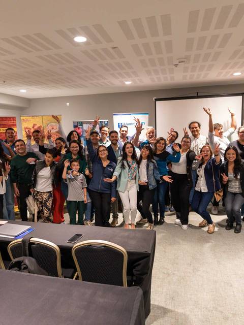 Un grupo grande de personas sonrientes posando juntas en un evento.