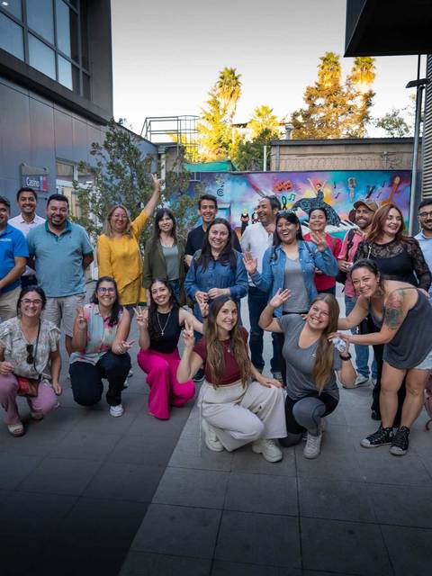 Un grupo de personas sonrientes se reúne en un evento al aire libre en Chile.
