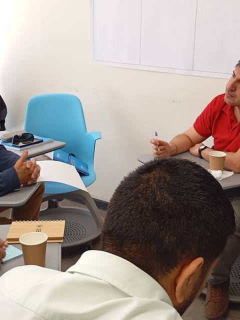 Un grupo de personas discutiendo en una sala de clases.