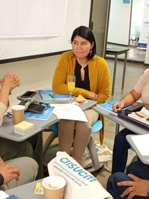 Un grupo de personas conversando y colaborando en una reunión.