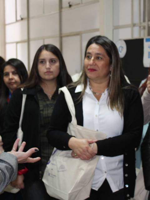 Un grupo de mujeres escucha atentamente a una expositora en un evento.