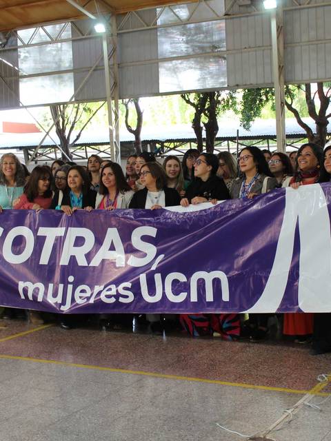 Un grupo de mujeres sosteniendo una pancarta en un evento de la universidad.