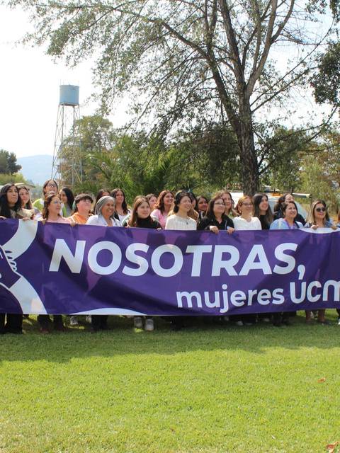 Un grupo de mujeres de UCM se reúne con un banner que dice 'NOSOTRAS, mujeres UCM'.