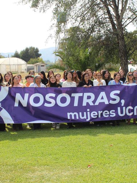 Un grupo de mujeres posando junto a una pancarta que celebra su identidad en la UCM.